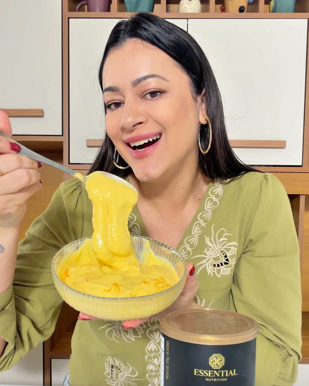 Lanna preparando sorvete de manga na cozinha, com embalagem de whey à frente